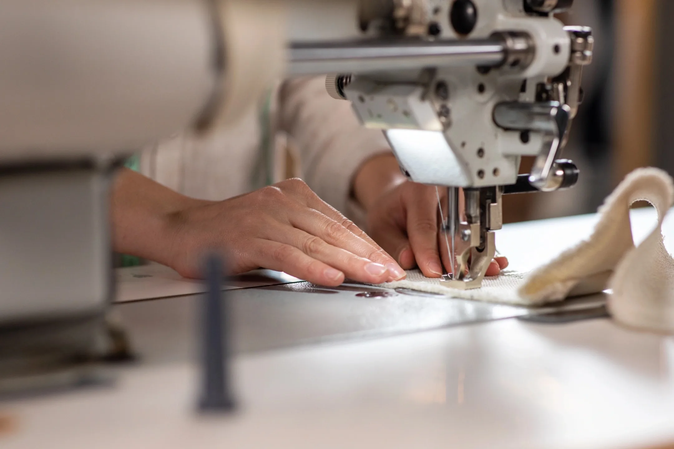 Manos guiando una tela en una máquina de coser